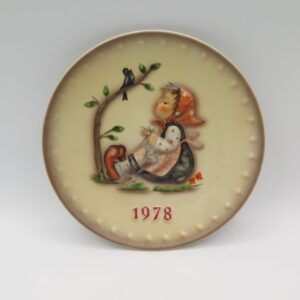 collector plate with sitting girl painted on it.